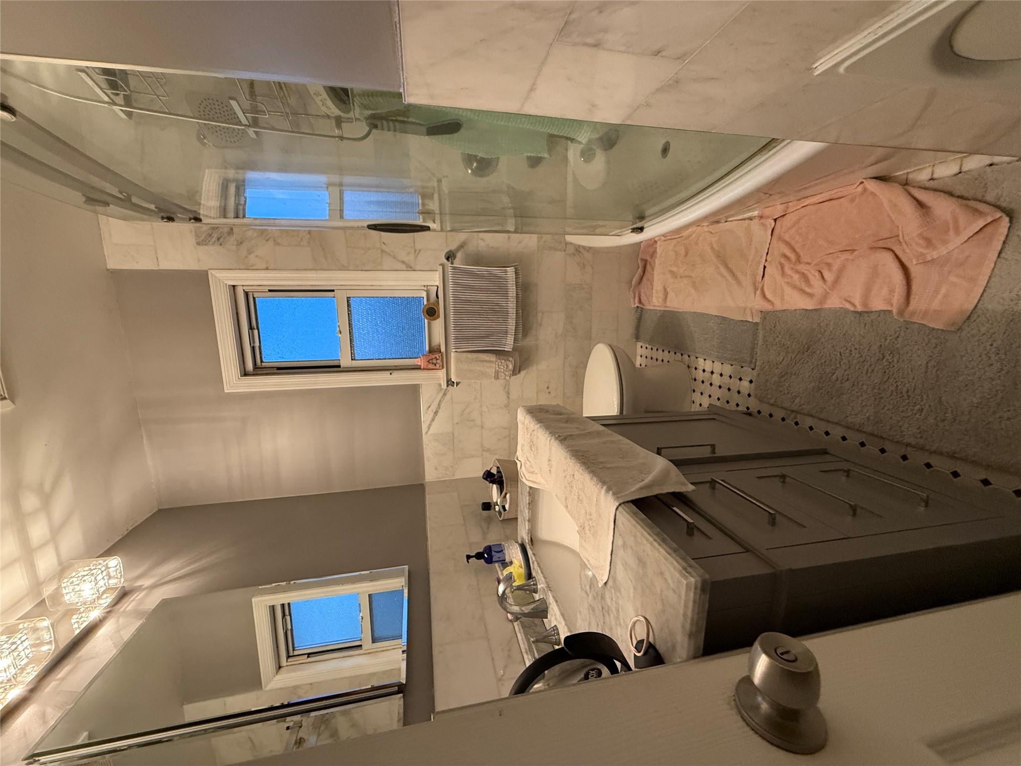 64-47 215th Street Queens, NY 11364 - Photo 10 of 15 a bathroom with a sink mirror vanity and toilet