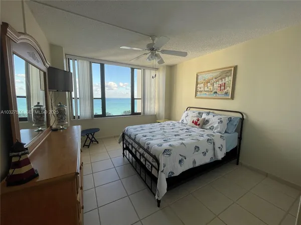 a spacious bedroom with a bed and a dresser next to a window