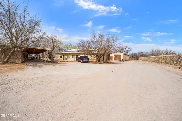 a view of a dirt road with a building in the background