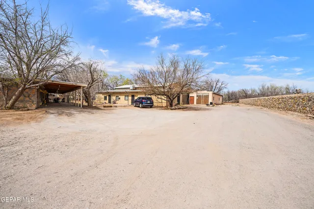 a view of a dirt road with a building in the background