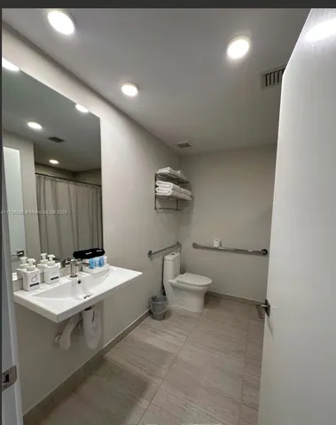 a bathroom with a toilet sink and mirror