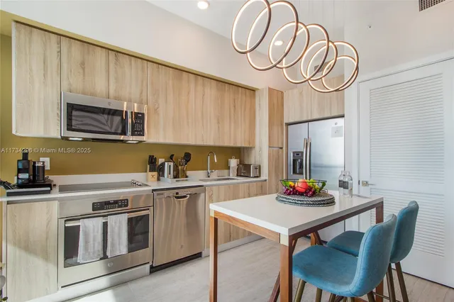 a kitchen with stainless steel appliances granite countertop a stove a sink dishwasher and cabinets with wooden floor