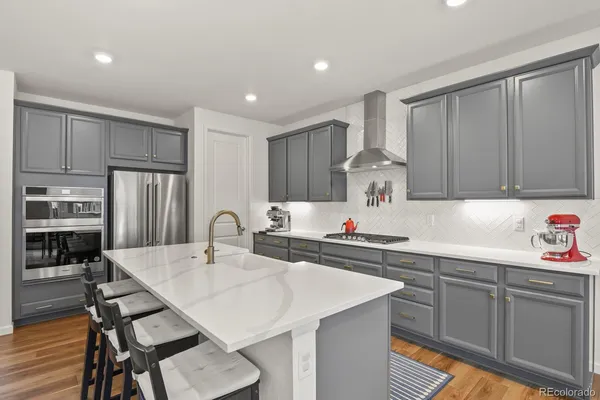 a kitchen with stainless steel appliances a table and chairs in it