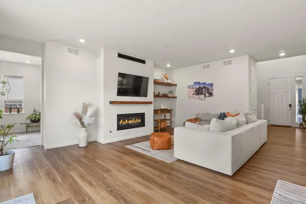 a living room with furniture a flat screen tv and a fireplace