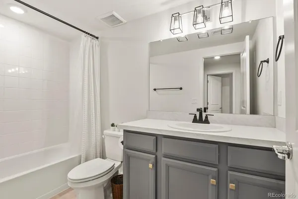 a bathroom with a sink vanity mirror and toilet