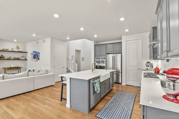 a large kitchen with stainless steel appliances lots of counter space and wooden floor