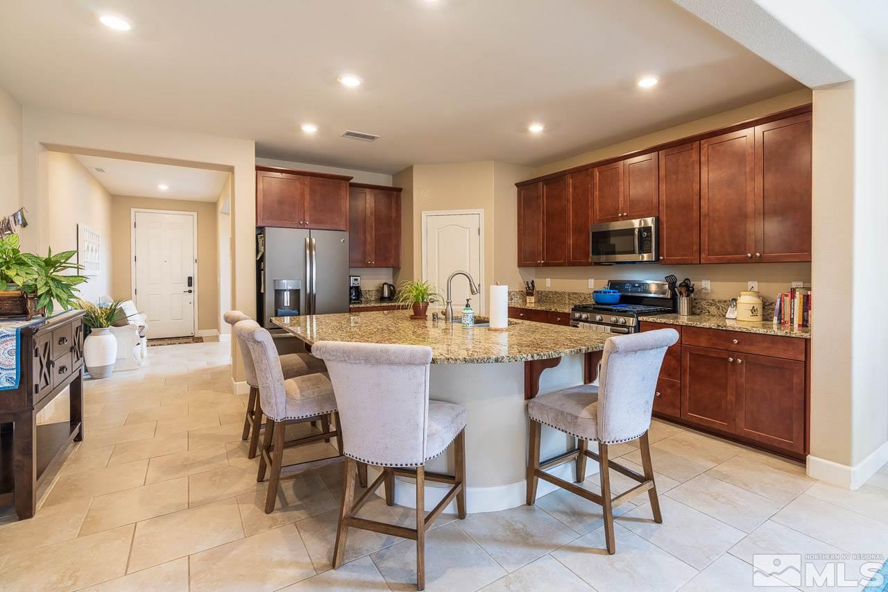 10155 Toltec Court Reno, NV 89521 - Photo 2 of 19 a kitchen with kitchen island a dining table chairs and a oven