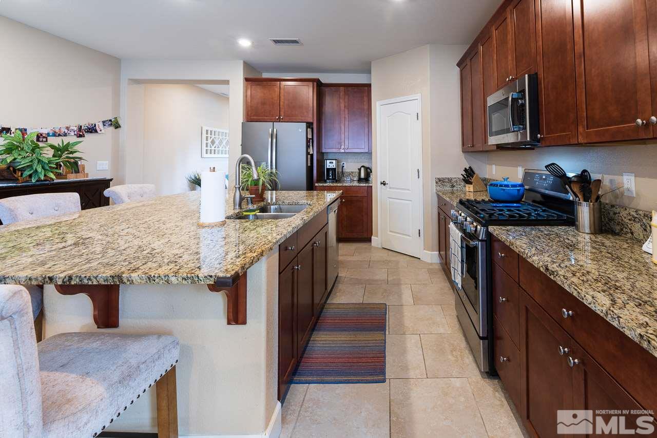 10155 Toltec Court Reno, NV 89521 - Photo 3 of 19 a kitchen with stainless steel appliances granite countertop a sink a stove and a wooden floors