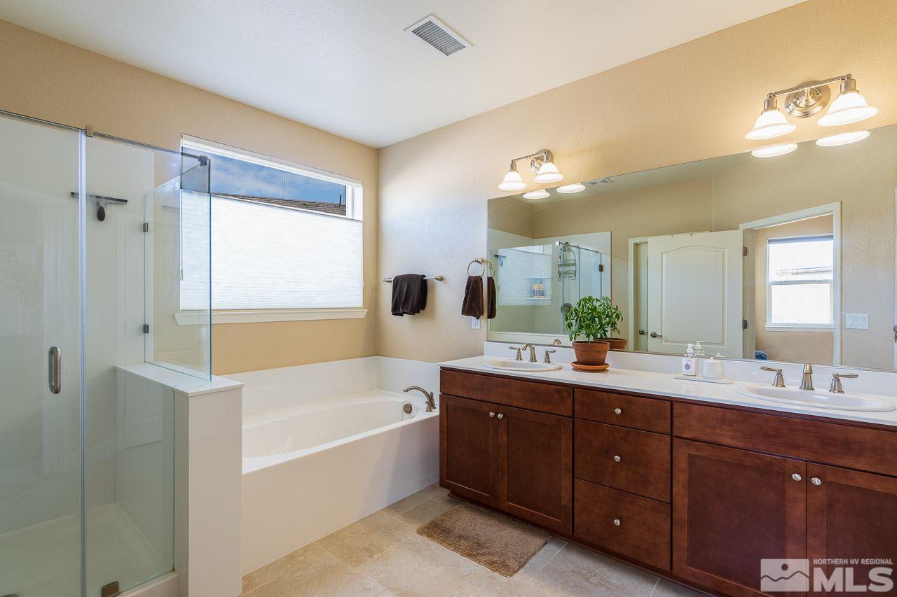 10155 Toltec Court Reno, NV 89521 - Photo 9 of 19 a bathroom with a tub a sink double vanity and mirror