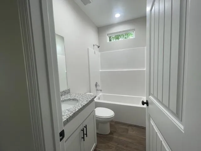 a bathroom with a granite countertop toilet a sink and bathtub