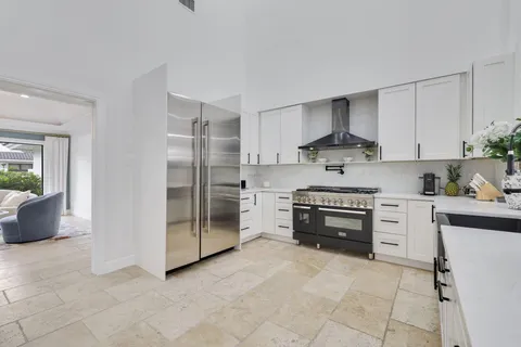 a large white kitchen with stainless steel appliances and white cabinets