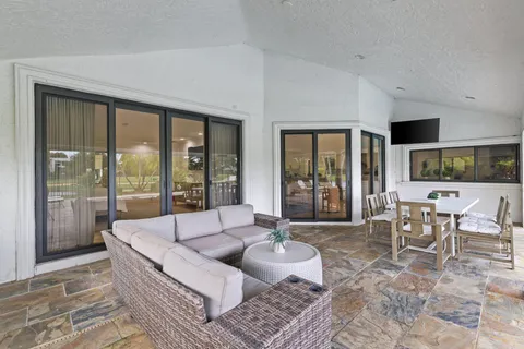a living room with furniture and large windows