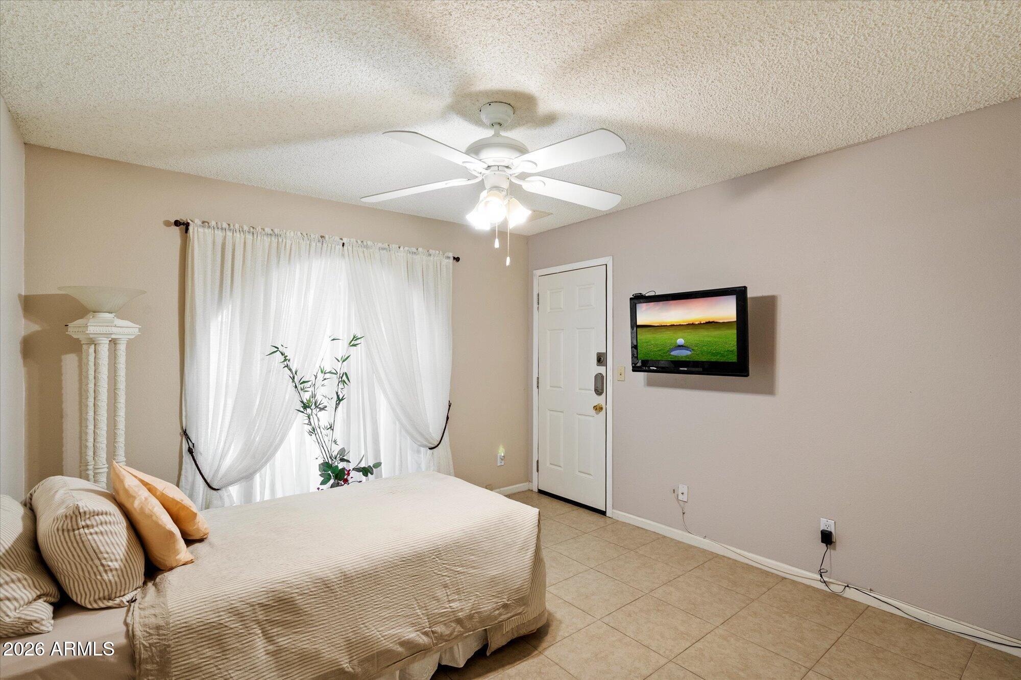 14242 North 9th Street Phoenix, AZ 85022 - Photo 11 of 26 a bedroom with a bed and a tv