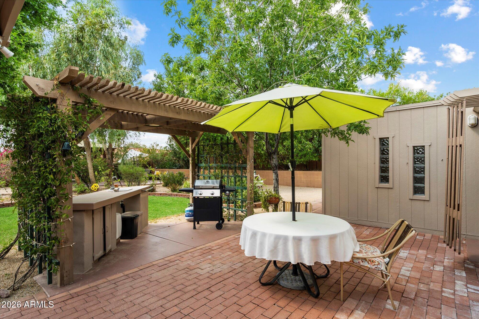 14242 North 9th Street Phoenix, AZ 85022 - Photo 20 of 26 a view of a patio with a table and chairs under an umbrella