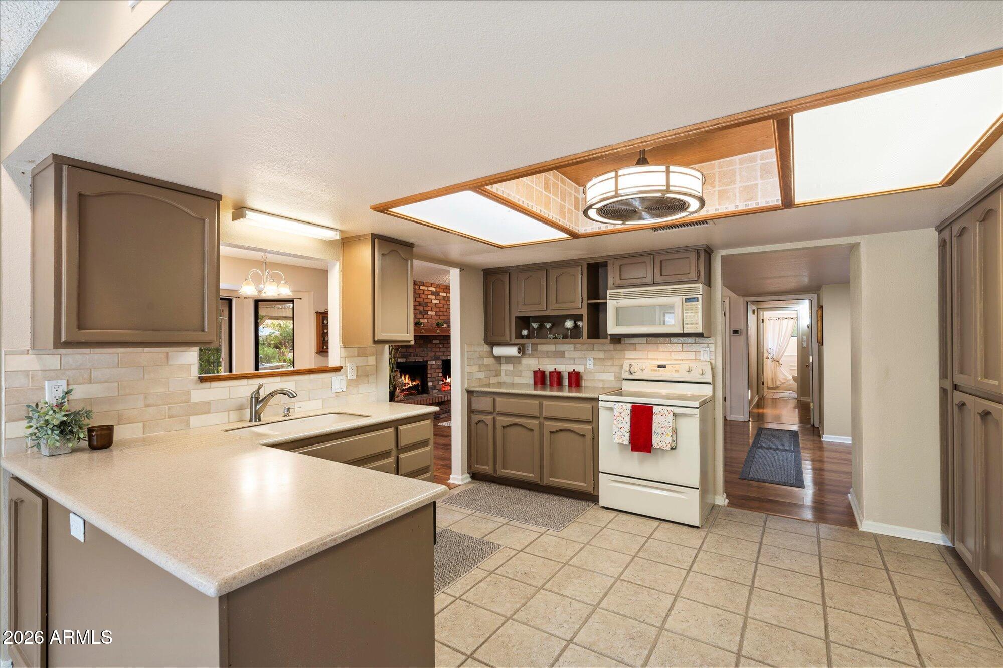 14242 North 9th Street Phoenix, AZ 85022 - Photo 2 of 26 a kitchen with a sink a stove and cabinets
