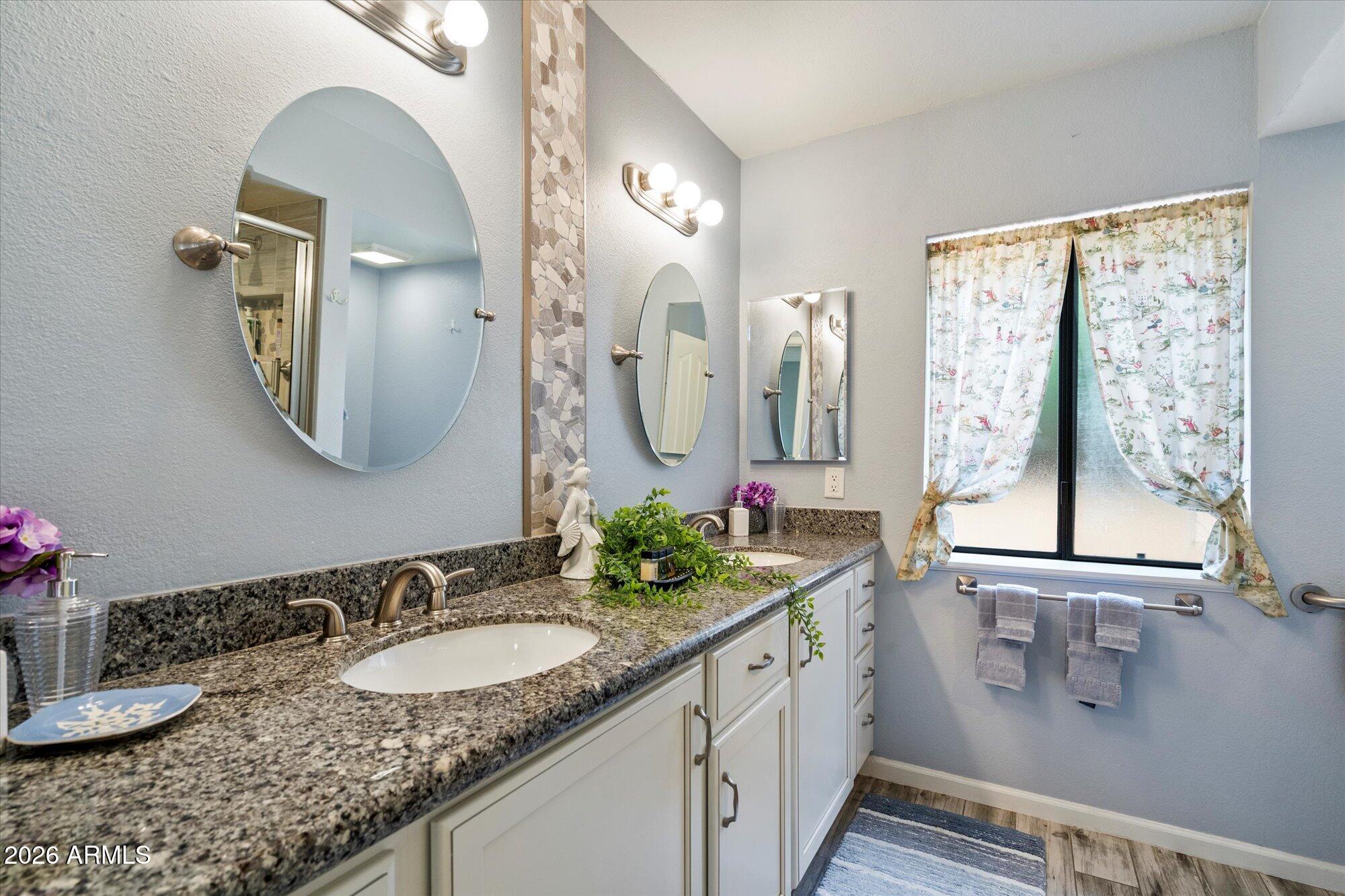 14242 North 9th Street Phoenix, AZ 85022 - Photo 9 of 26 a bathroom with a granite countertop sink a large mirror and a window