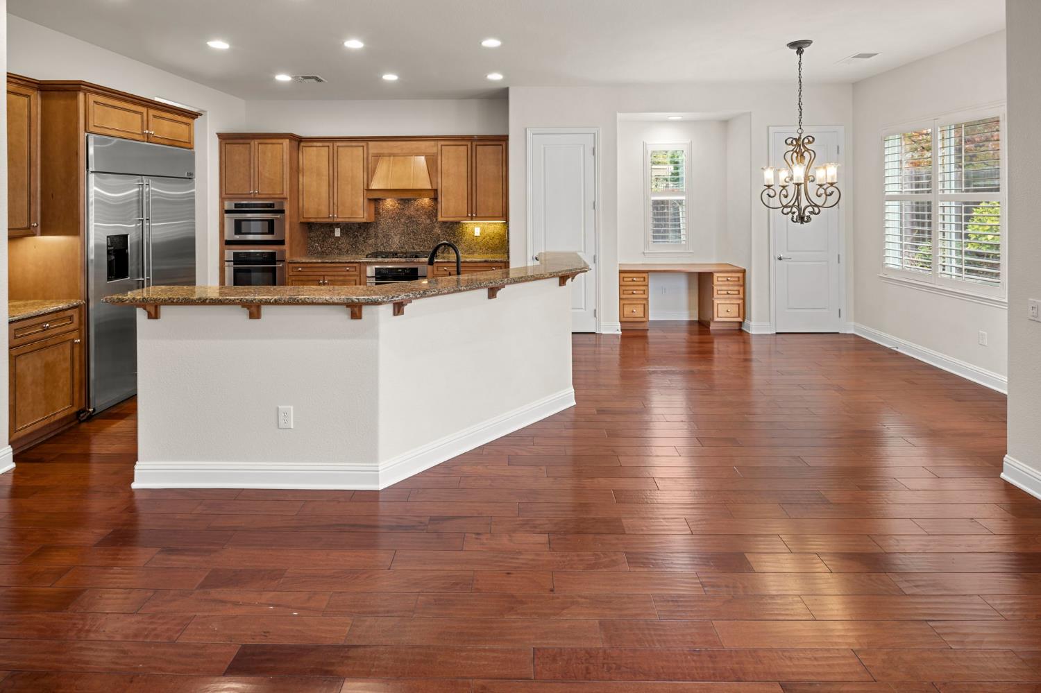 2144 Penstone Loop Roseville, CA 95747 - Photo 23 of 60 an open kitchen with wooden floor and large windows