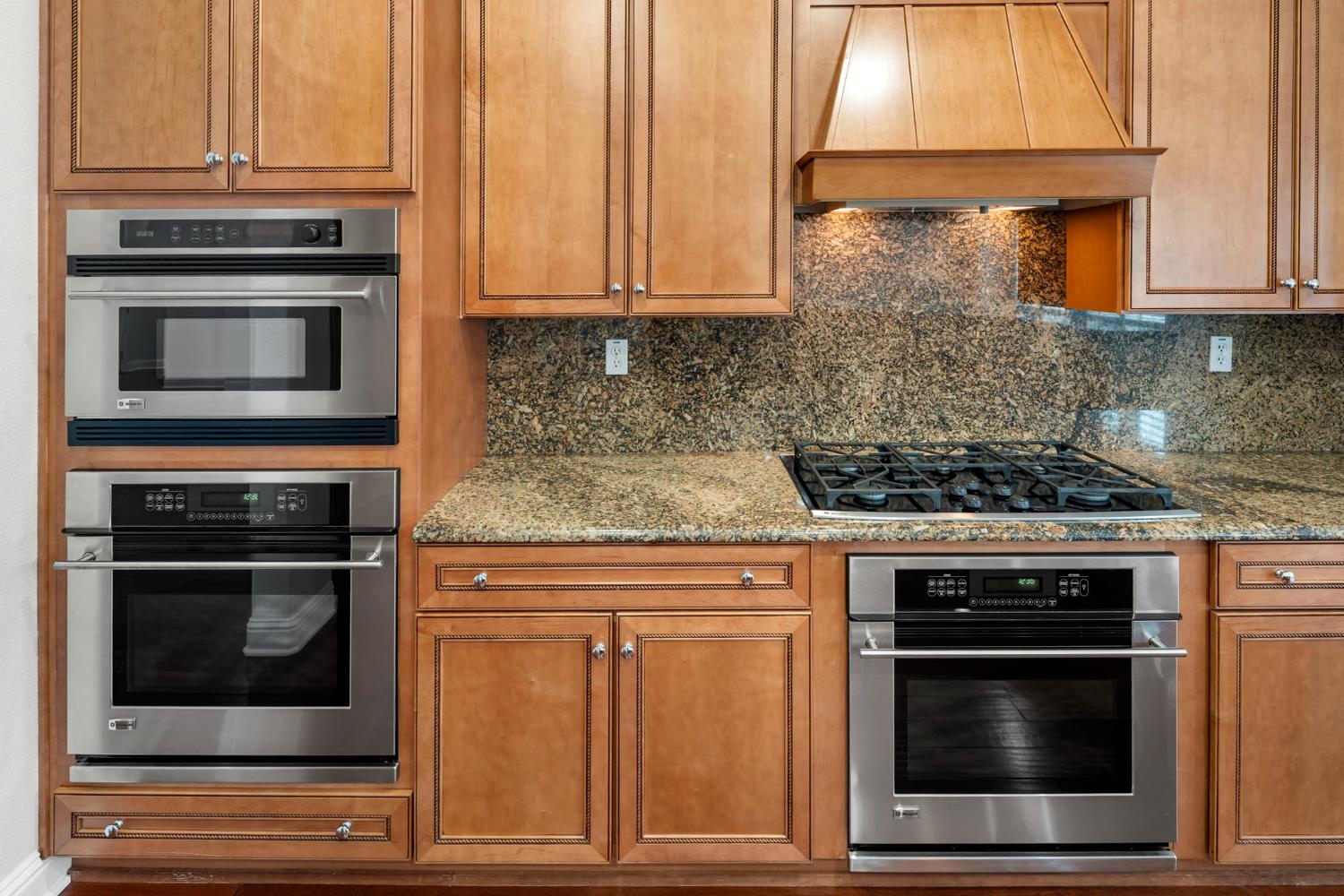 2144 Penstone Loop Roseville, CA 95747 - Photo 27 of 60 a kitchen with granite countertop a stove and a microwave