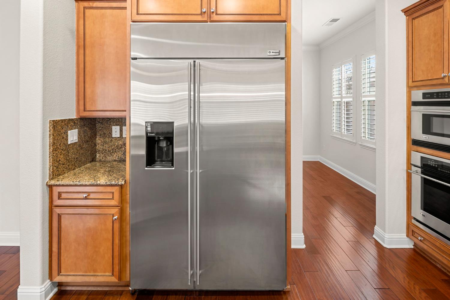 2144 Penstone Loop Roseville, CA 95747 - Photo 28 of 60 a kitchen with a refrigerator and wooden floor