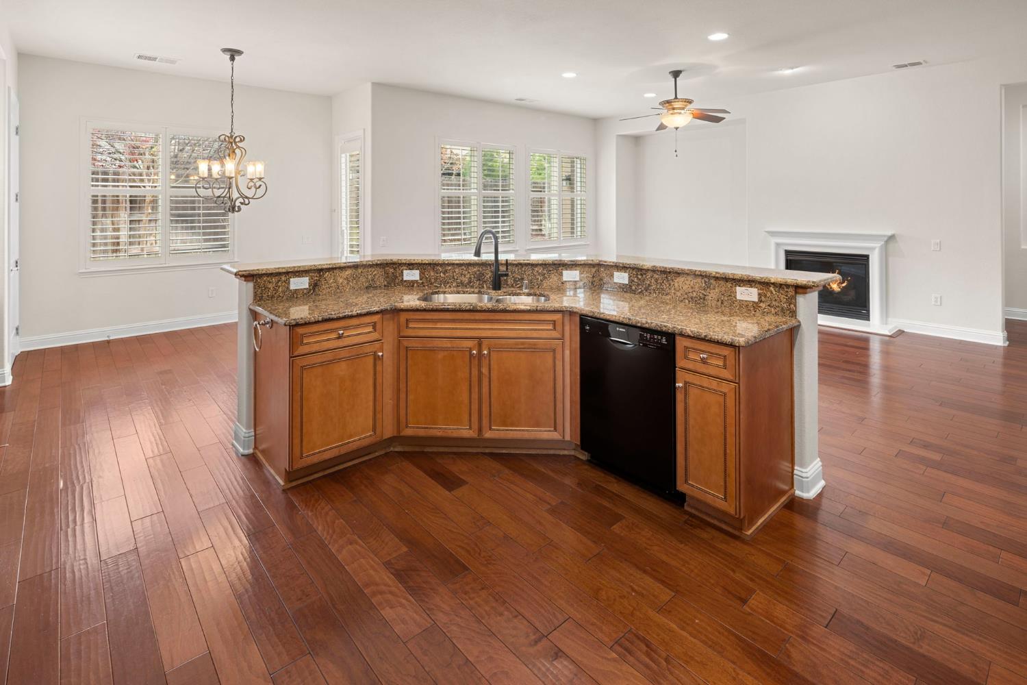 2144 Penstone Loop Roseville, CA 95747 - Photo 30 of 60 a kitchen with kitchen island granite countertop wooden floors and a sink