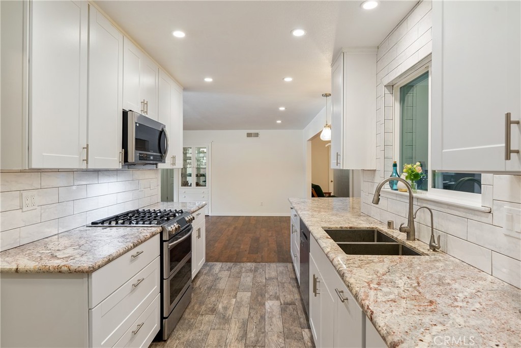 3388 Ramona Road Atascadero, CA 93422 - Photo 15 of 55 The kitchen features a timeless subway tile backsplash and wood looking ceramic tile floors.
