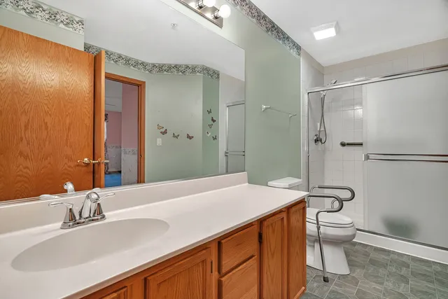 a bathroom with a sink a toilet and shower