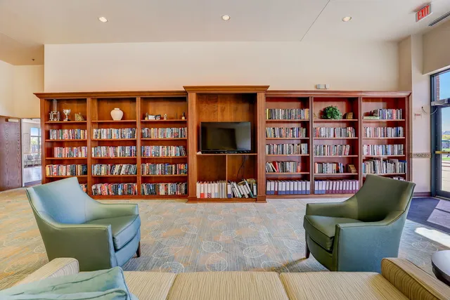 a living room with furniture and a bookshelf