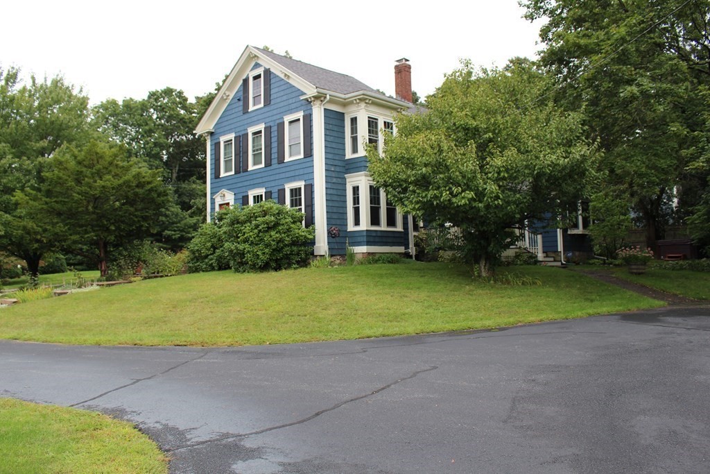 a front view of house with outdoor space and trees around