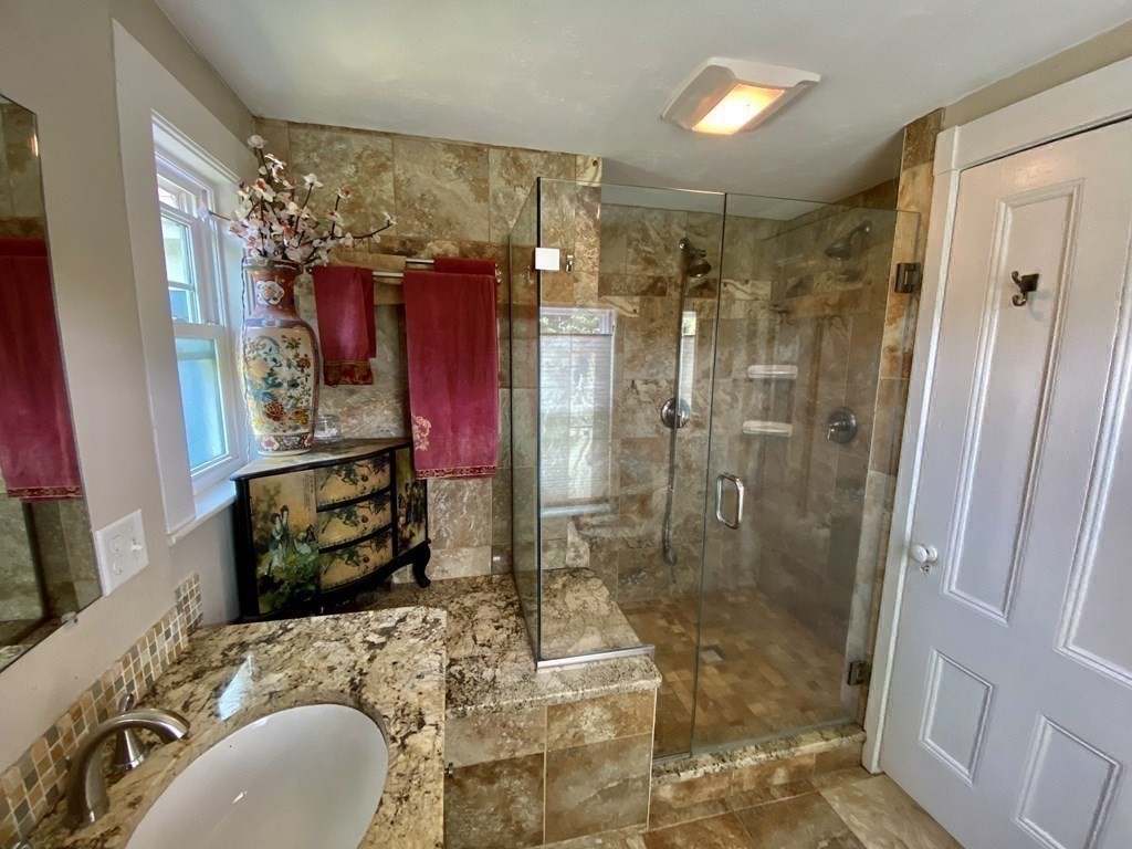 7 Grasshopper Lane Walpole, MA 02081 - Photo 27 of 42 a bathroom with a granite countertop sink a mirror and shower