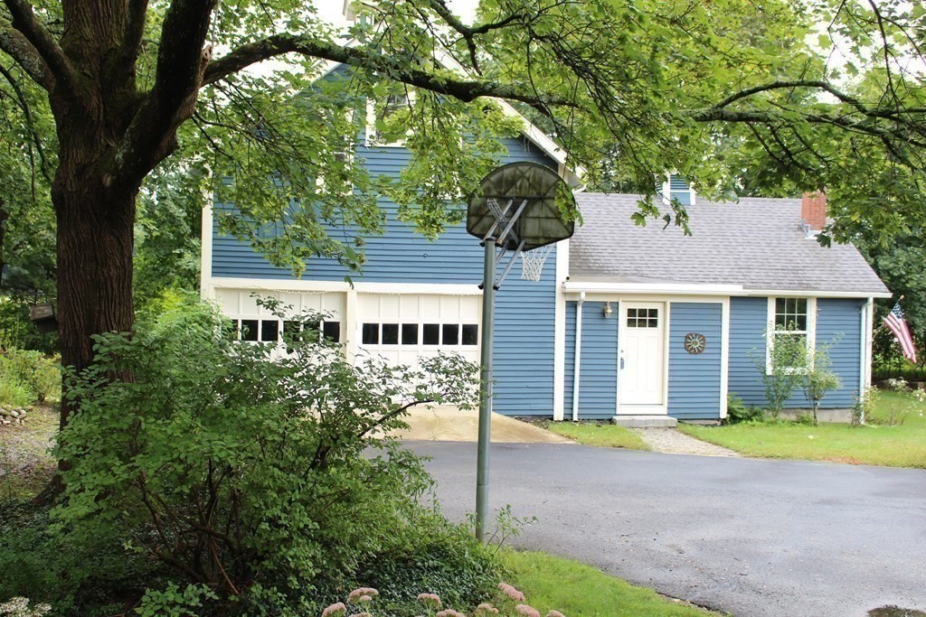 7 Grasshopper Lane Walpole, MA 02081 - Photo 40 of 42 a front view of a house with a garden and trees