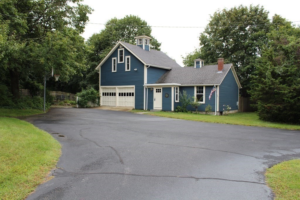 7 Grasshopper Lane Walpole, MA 02081 - Photo 41 of 42 a front view of a house with a garden and trees