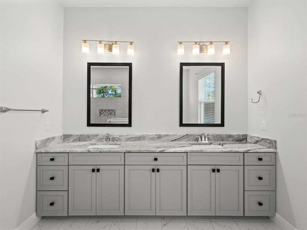 11981 Robina Road Weeki Wachee, FL 34614 - Photo 25 of 93 a bathroom with a granite countertop double vanity sink and mirror