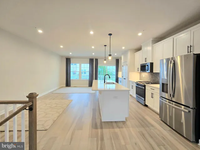 a kitchen with stainless steel appliances a refrigerator and a stove top oven