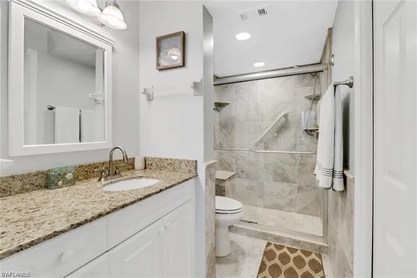 a bathroom with a sink mirror vanity and toilet