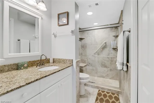 a bathroom with a sink mirror vanity and toilet