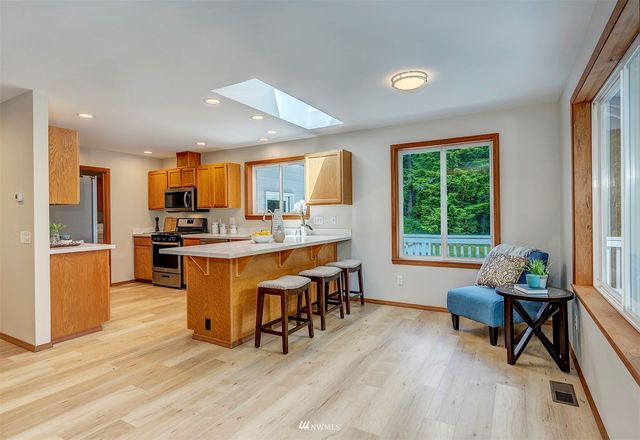 a living room filled with furniture and kitchen view