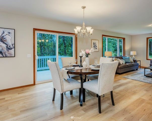 a view of a dining room with furniture a chandelier and wooden floor