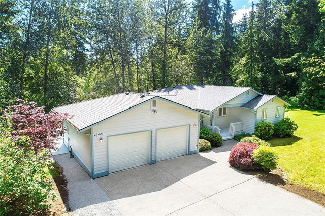 a white house covered with tall trees