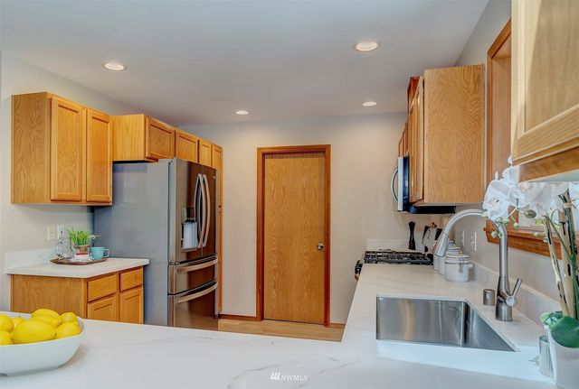 a kitchen with stainless steel appliances granite countertop a refrigerator and a sink
