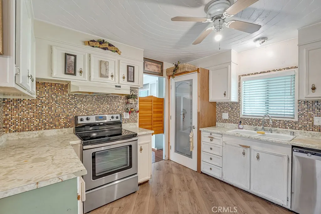 9999 Foothill, Unit 48 Rancho Cucamonga, CA 91730 - Photo 16 of 38 a kitchen with stainless steel appliances a stove sink and refrigerator
