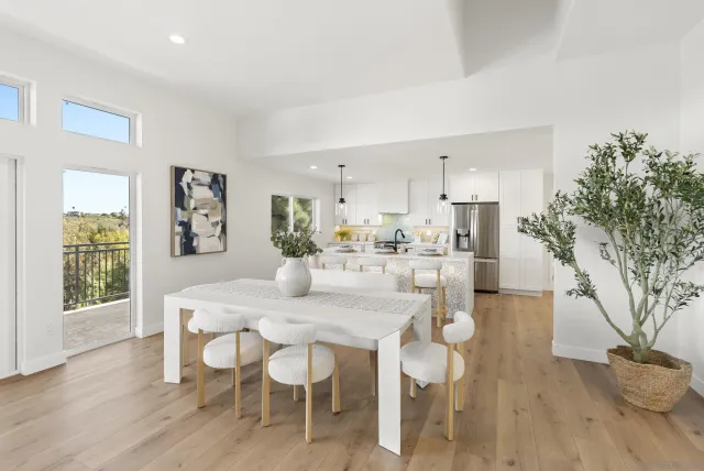 a kitchen with stainless steel appliances kitchen island granite countertop a stove a sink a dining table and chairs with wooden floor