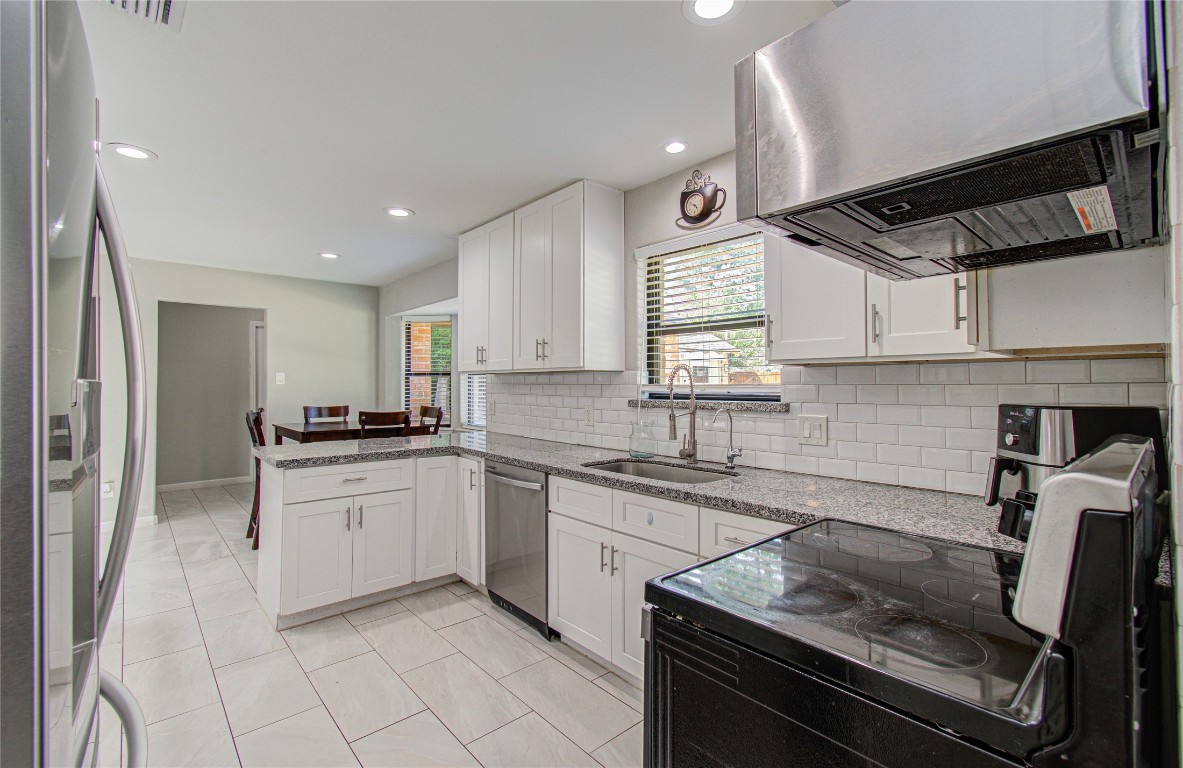 2507 Encreek Road Houston, TX 77068 - Photo 13 of 47 a kitchen with granite countertop a sink stainless steel appliances and cabinets