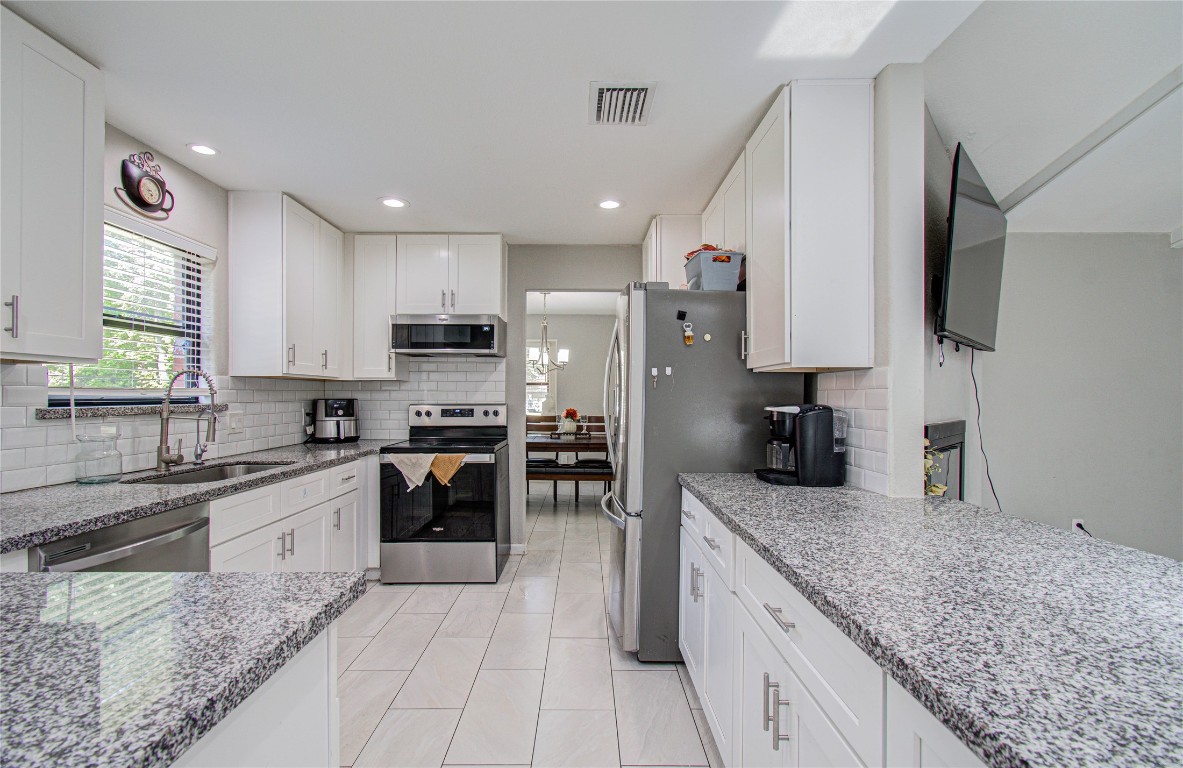 2507 Encreek Road Houston, TX 77068 - Photo 15 of 47 a kitchen with stainless steel appliances granite countertop a sink stove and refrigerator