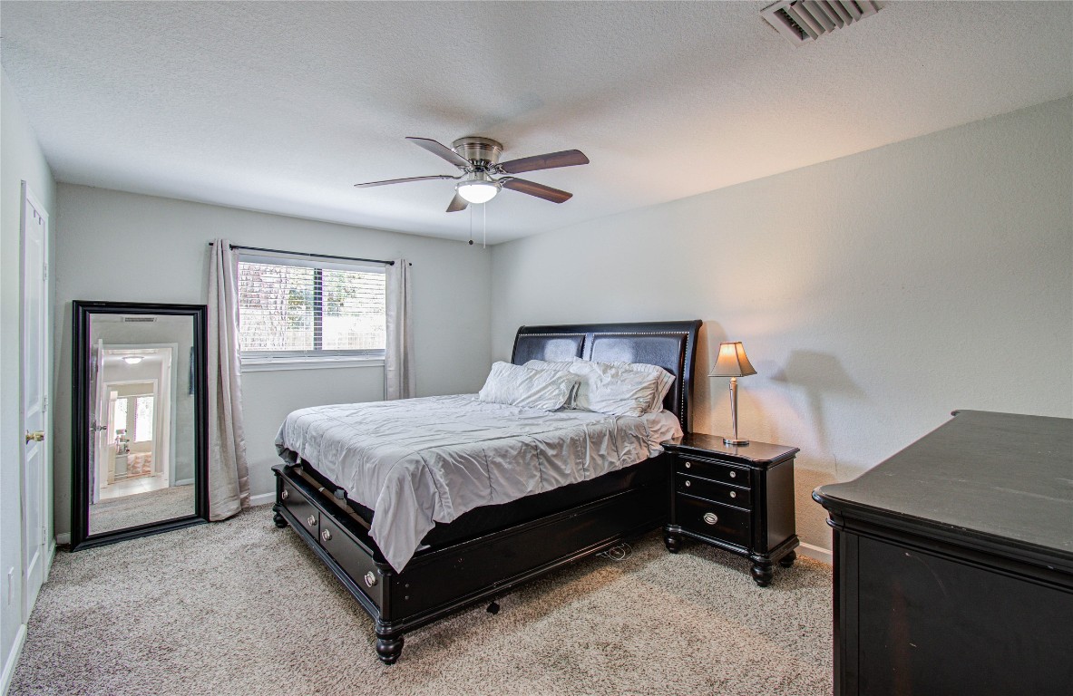 2507 Encreek Road Houston, TX 77068 - Photo 28 of 47 a spacious bedroom with a bed and a chandelier