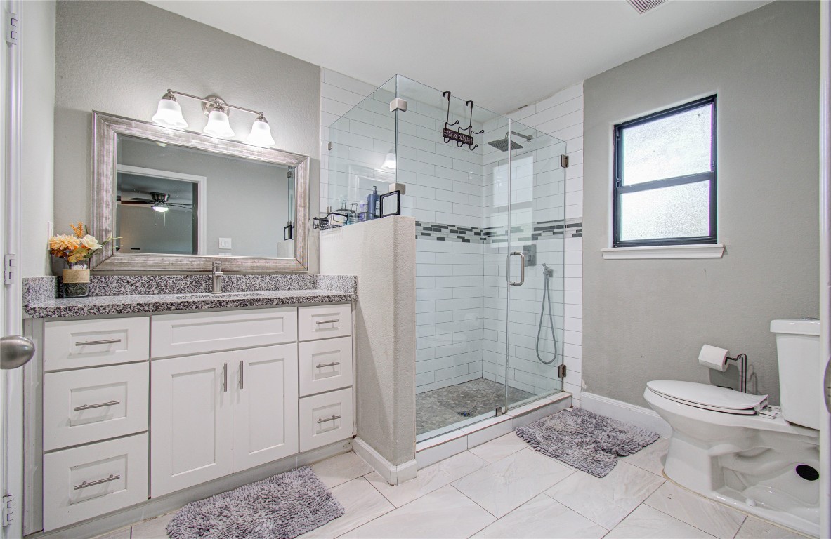 2507 Encreek Road Houston, TX 77068 - Photo 30 of 47 a bathroom with a granite countertop sink a toilet a mirror and shower