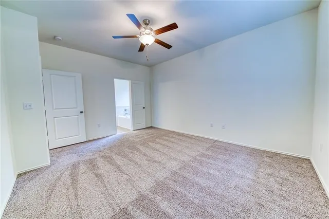 an empty room with closet and fan