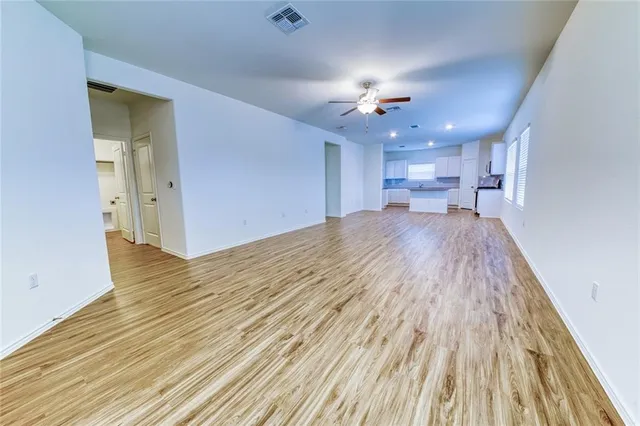 a view of a room with wooden floor and ceiling fan