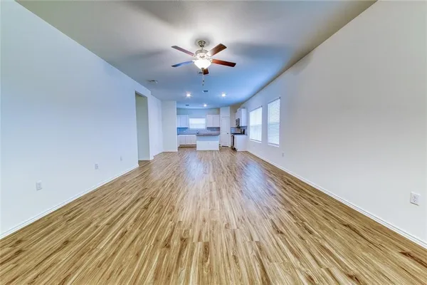 a view of a kitchen with a ceiling fan and wooden floor