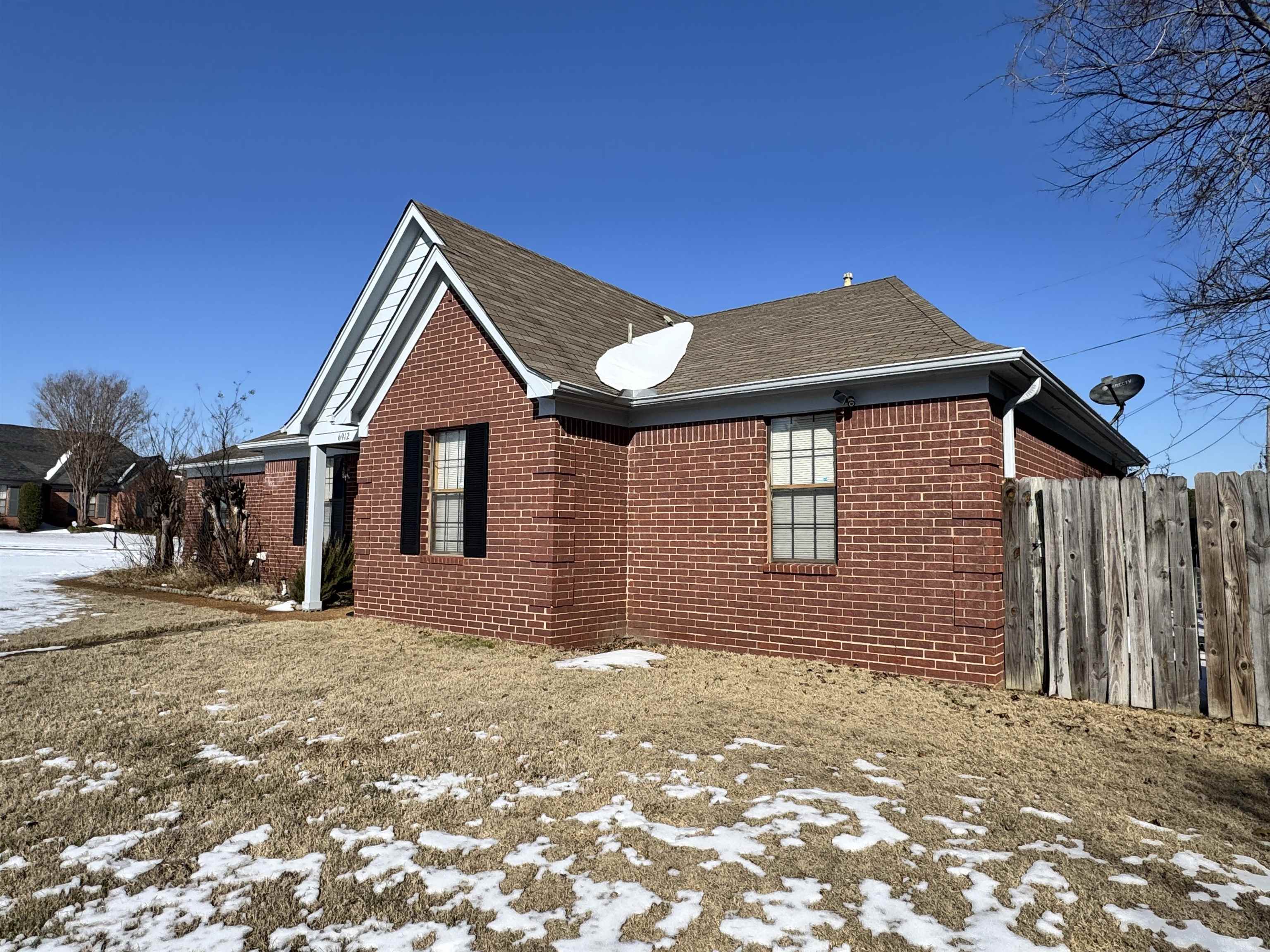 6912 Pleasantwood Road Memphis, TN 38141 - Photo 19 of 20 View of snow covered exterior with brick siding and roof with shingles