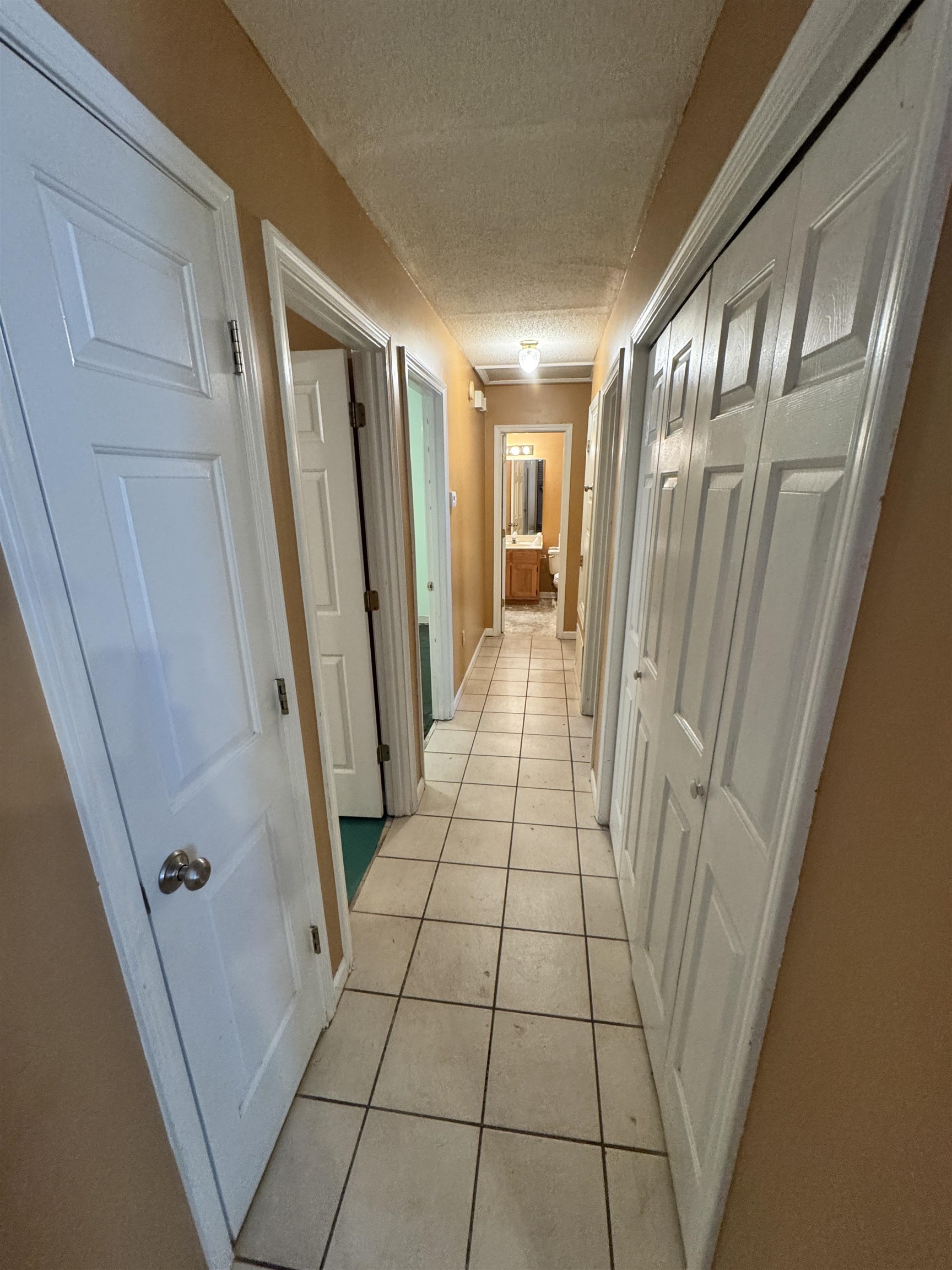 6912 Pleasantwood Road Memphis, TN 38141 - Photo 5 of 20 Hallway featuring a textured ceiling and light tile patterned flooring